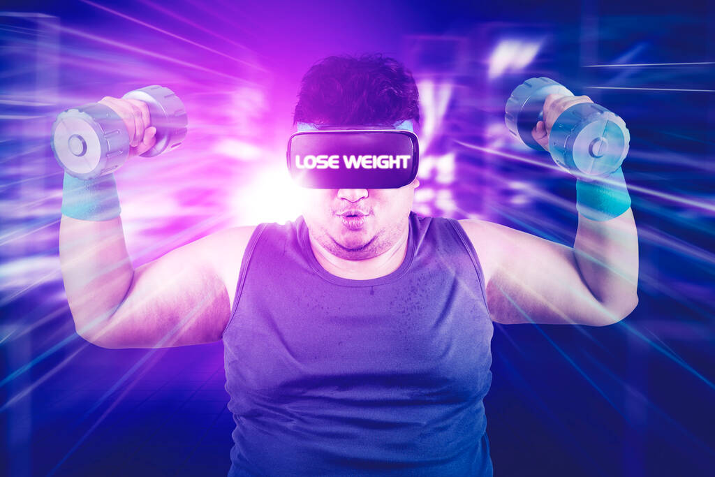 Tlustý muž pomocí VR brýle se zhubnout text při cvičení s činky v kyberprostoru s virtuálním pozadí obrazovky - Fotografie, Obrázek