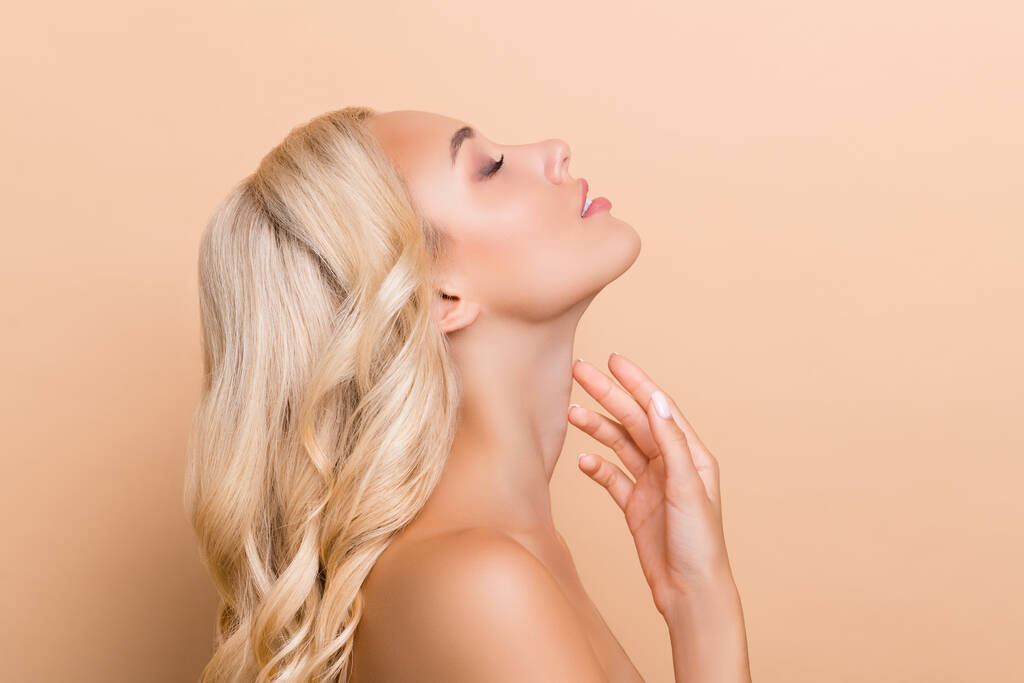 Foto lateral del perfil de impresionante adorable señora tacto cuello levantamiento anti edad arrugas corrección aislada en color beige fondo - Foto, imagen