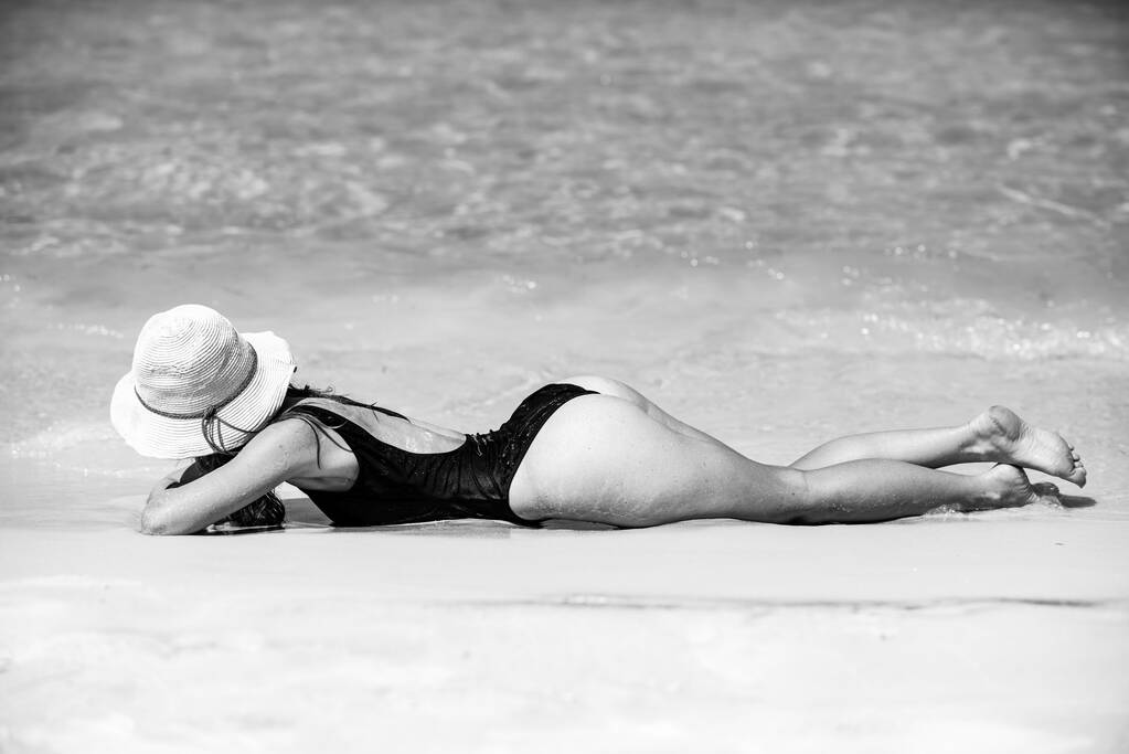 Summer sunbath. Summertime woman on beach. Sexy butt in bikini. Vacation on sea. Girl sunbath near ocean. - Valokuva, kuva