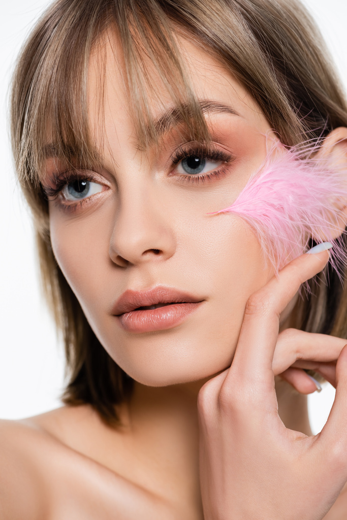 sensual young woman with blue eyes and pink feather on face isolated on white - Fotografie, Obrázek