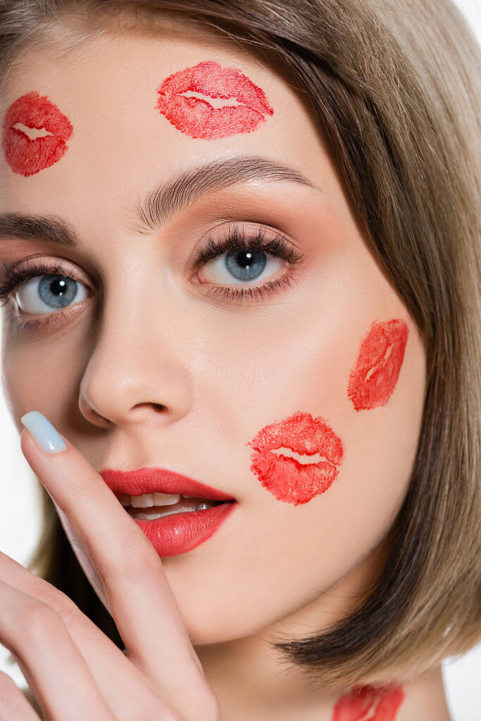 close up of young woman with red kiss prints on cheeks and body isolated on white - Foto, afbeelding
