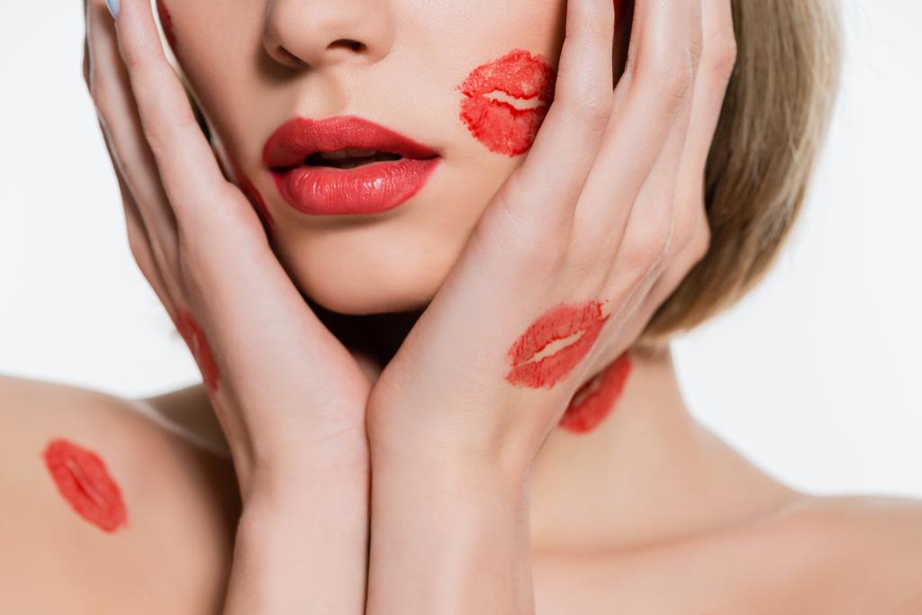 cropped view of young woman with red kiss prints on body touching face isolated on white - Photo, image