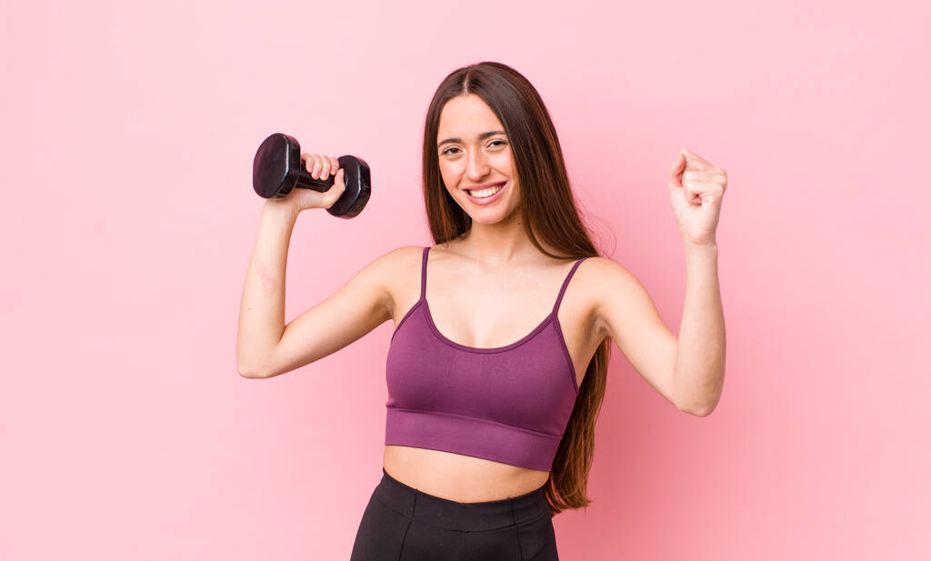young adult pretty woman with a dumbbell. fitness concept - Photo, Image