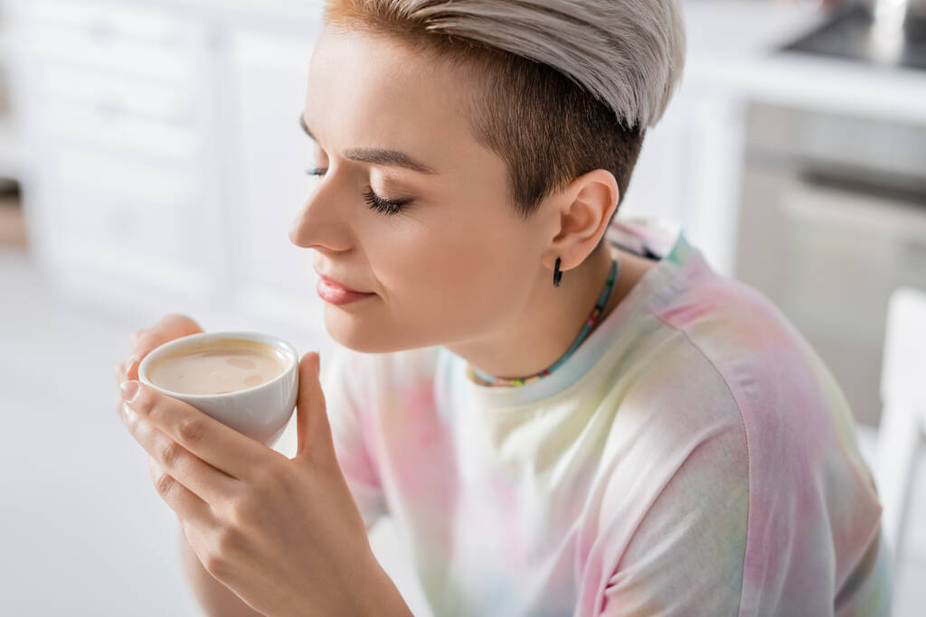 young woman with closed eyes enjoying flavor of morning coffee  - Foto, afbeelding