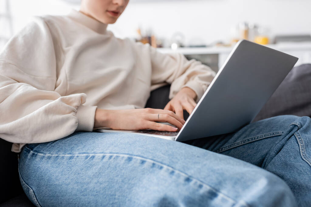 cropped view of woman typing on laptop on blurred background - Photo, image