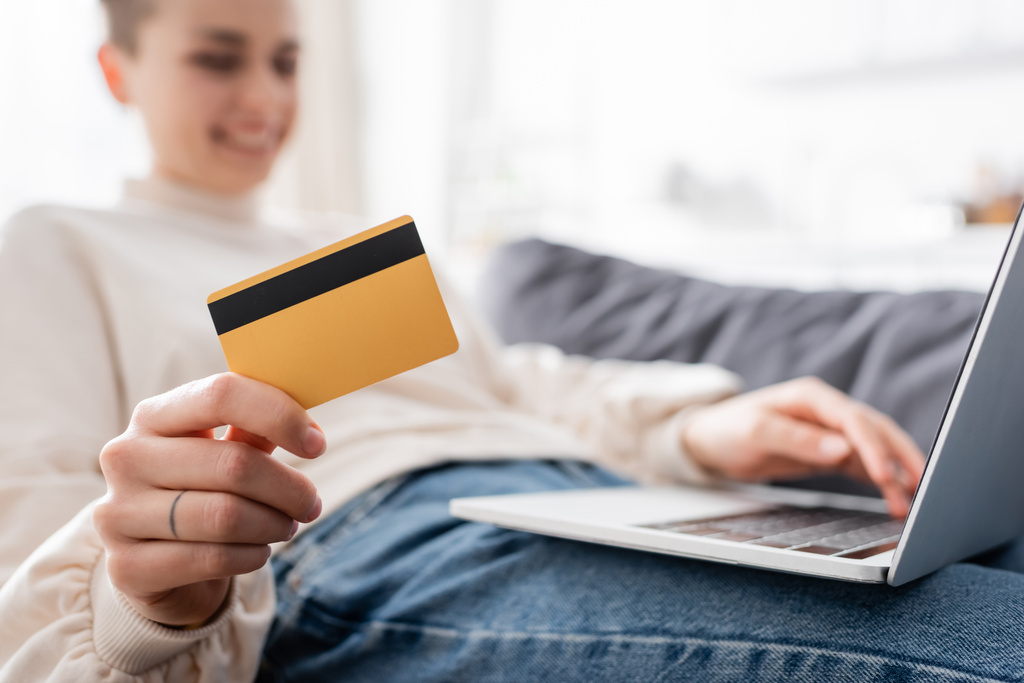 selective focus of credit card and laptop near woman smiling on blurred background - Φωτογραφία, εικόνα