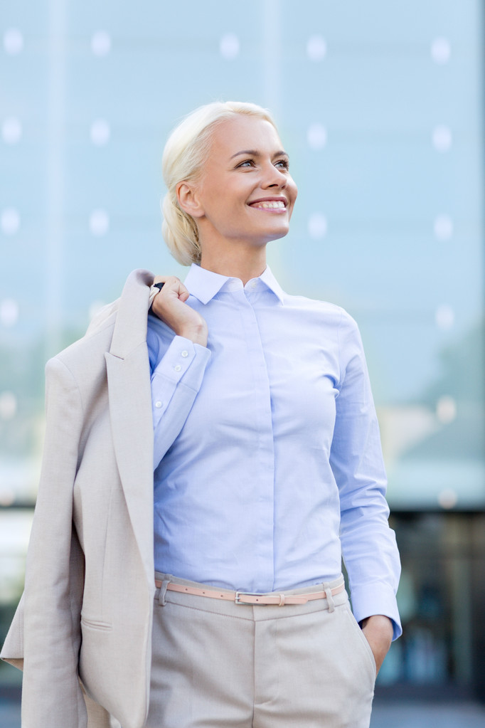 молодая улыбающаяся деловая женщина над офисным зданием
 - Фото, изображение
