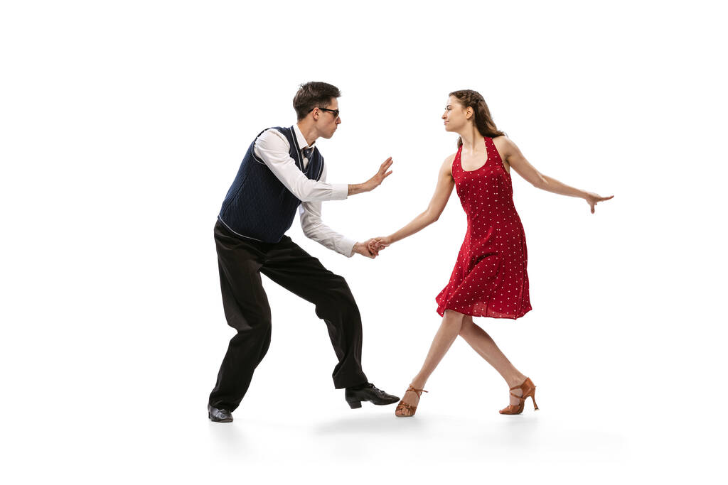 Красива дівчина і стильний чоловік в вінтажному ретро-стилі танцюють ізольовано на білому тлі. Вічні традиції, 60-70-ті роки американський стиль моди та мистецтво
 - Фото, зображення