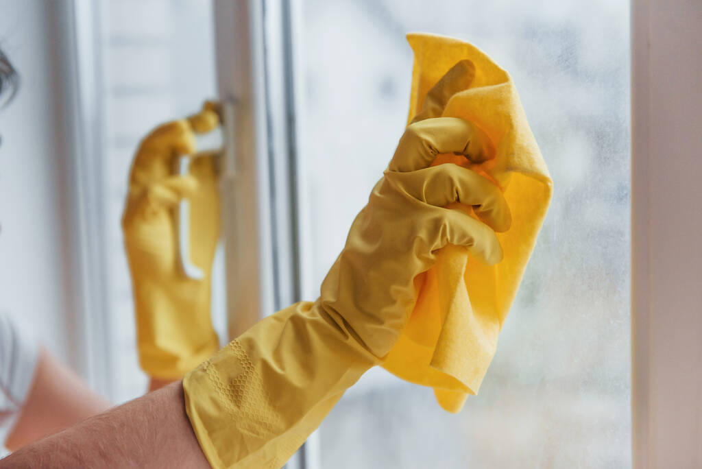 Femme au foyer en uniforme jaune nettoyage des fenêtres. Conception de rénovation maison. - Photo, image