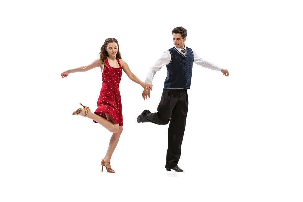 Beautiful girl and stylish man in vintage retro style outfits dancing isolated on white background. Timeless traditions, 60s,70s american fashion style and art - 写真・画像