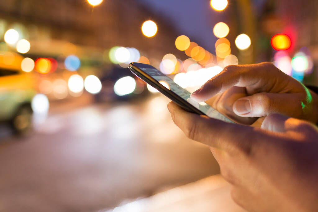 Mann benutzte sein Handy auf der Straße, Nachtlicht bokeh Hintergrund - Foto, Bild