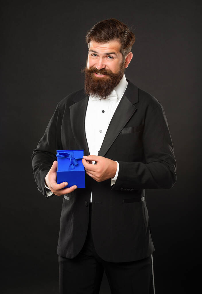 happy man in tuxedo bow tie on black background with business reward box. occasion greeting. - Fotografie, Obrázek