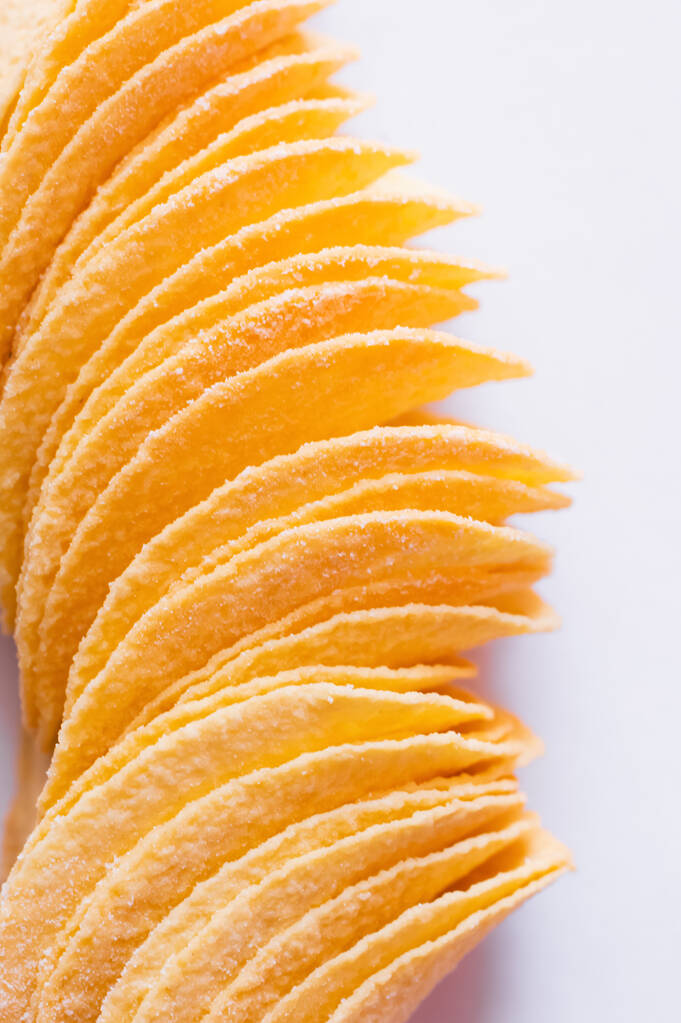 close up of salty and fried potato chips on white - Foto, immagini