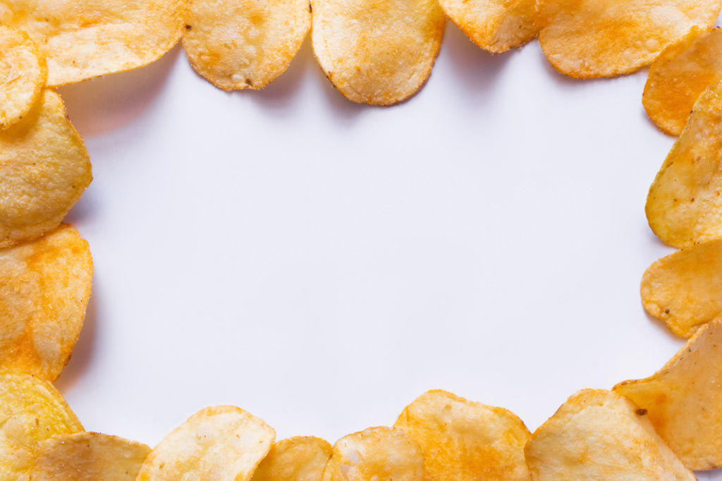 flat lay view of delicious, fried and salty potato chips on white - Foto, Bild