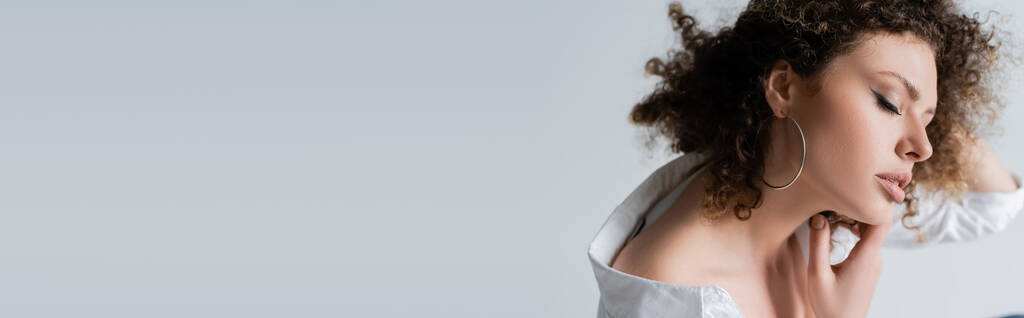 Fiatal nő blúzban megható nyak elszigetelt fehér, banner  - Fotó, kép