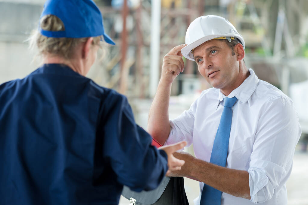 man telling woman she should be wearing a hardhat - Photo, image