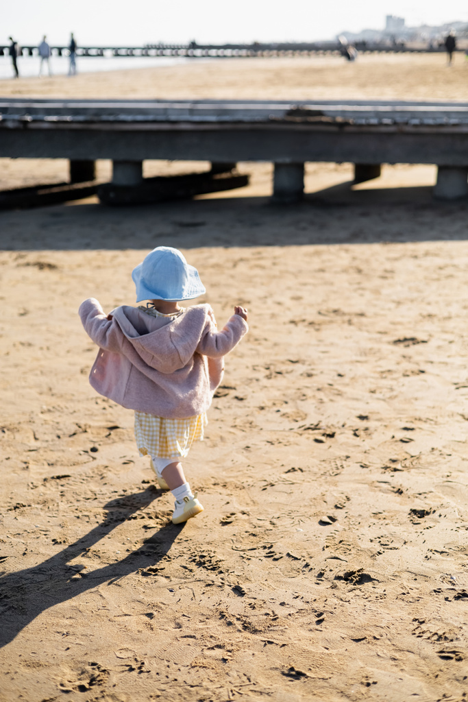 Back view of toddler child running on beach in Italy  - Photo, Image