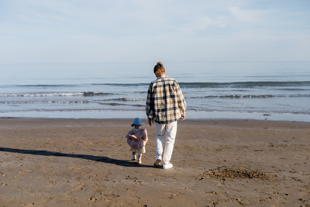 Takaisin näkymä isä ja lapsi tytär kävely hiekkarannalla lähellä adriatic meri Italiassa  - Valokuva, kuva