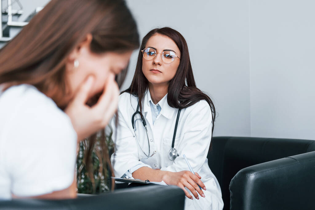 У дівчини психічний розлад і плач. Молода жінка відвідує жінку-лікаря в сучасній клініці
. - Фото, зображення
