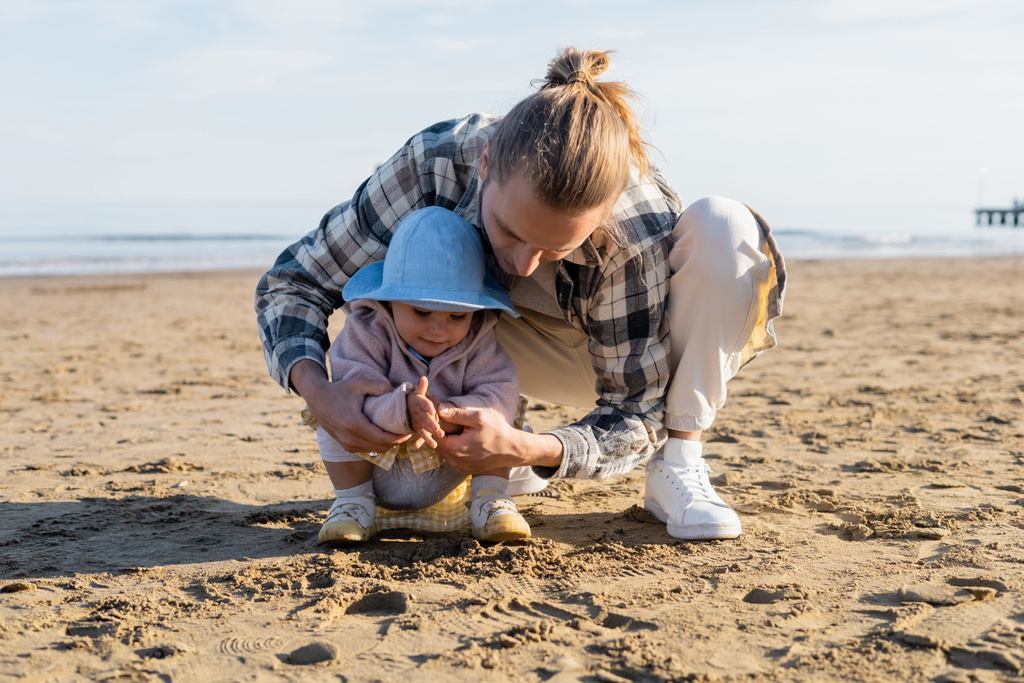Père et fille jouant avec le sable sur la plage de Trévise - Photo, image