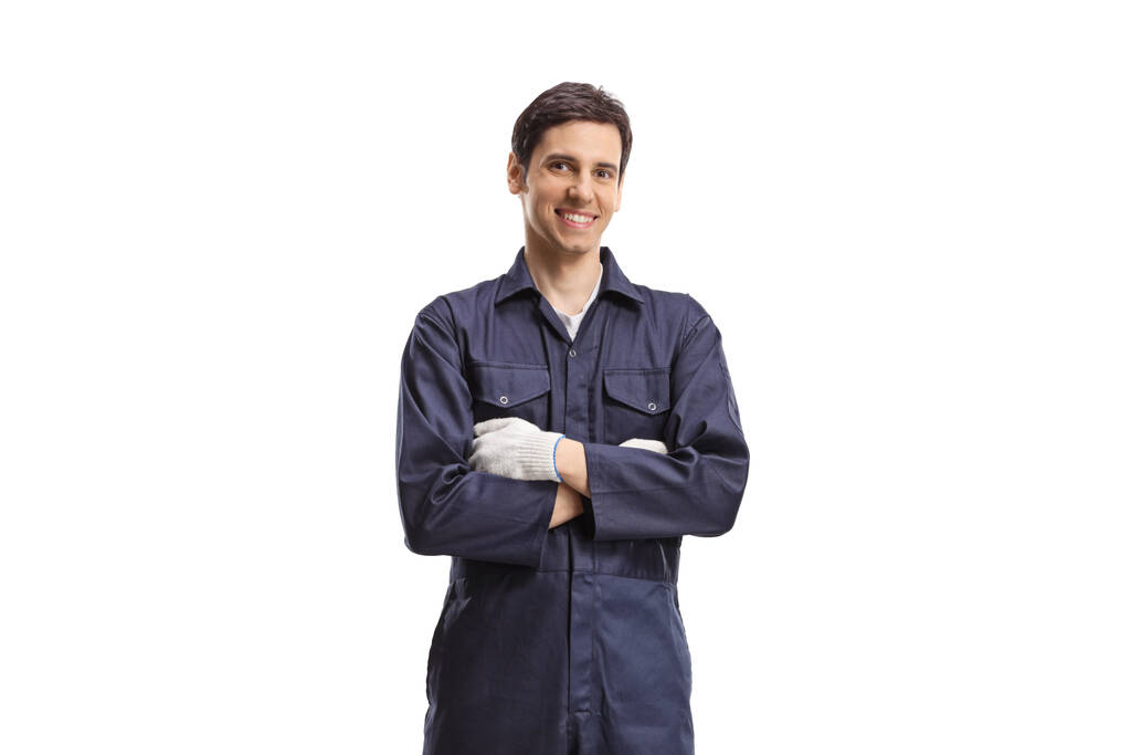 Uśmiechnięty pracownik płci męskiej w mundurze pozujący ze skrzyżowanymi ramionami na białym tle - Zdjęcie, obraz