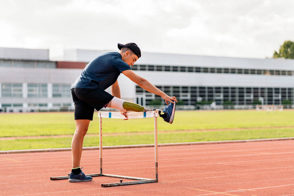 Behindertensportler dehnt sich mit Beinprothese. - Foto, Bild