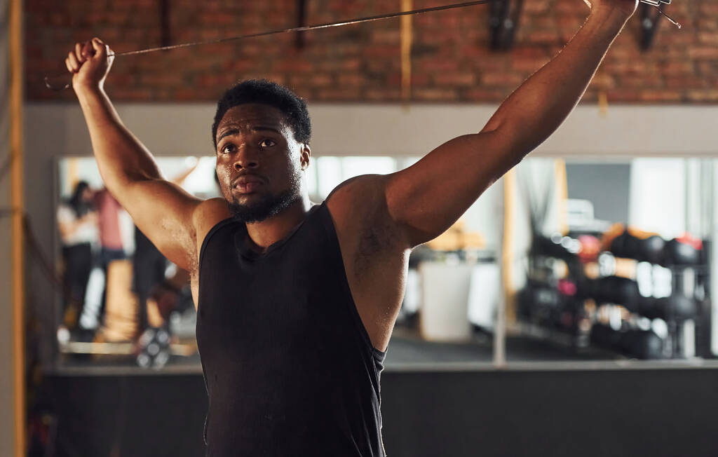 Erős afro-amerikai férfi sportos ruhában áll az edzőteremben. - Fotó, kép