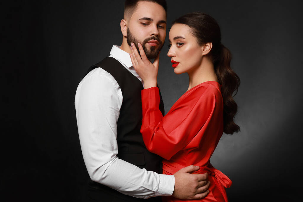 Handsome bearded man with sexy lady on dark background - Photo, Image