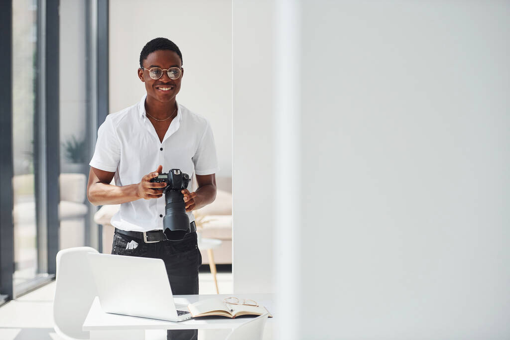 Kamera test ediliyor. Resmi giyinmiş genç Afro-Amerikan adam ofiste.. - Fotoğraf, Görsel