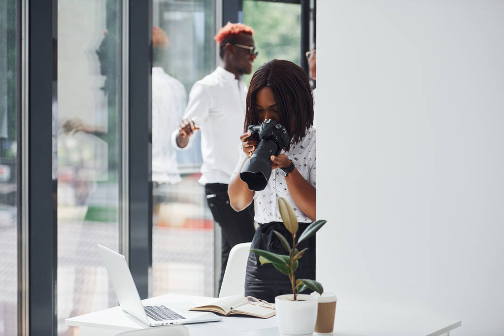 Frau testet Kamera. Gruppe afrikanisch-amerikanischer Geschäftsleute arbeitet gemeinsam im Büro. - Foto, Bild