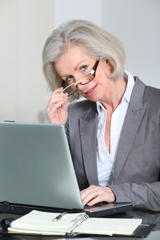 Старша бізнес-леді з окулярами, що працюють в офісі
 - Фото, зображення