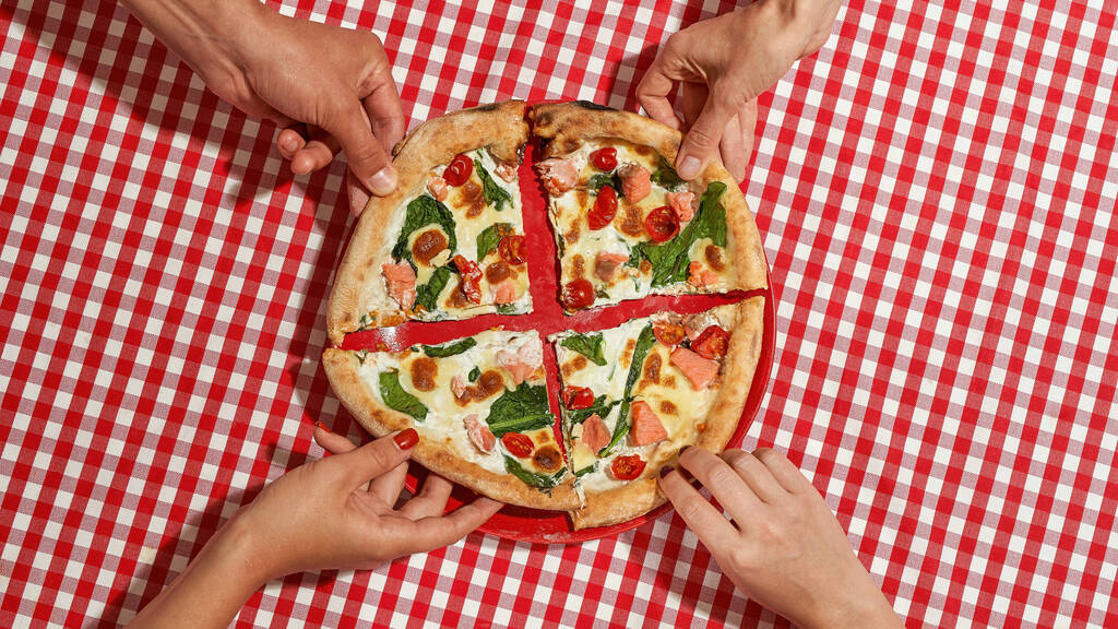 Руки людей беруть шматочки піци з тарілок
 - Фото, зображення
