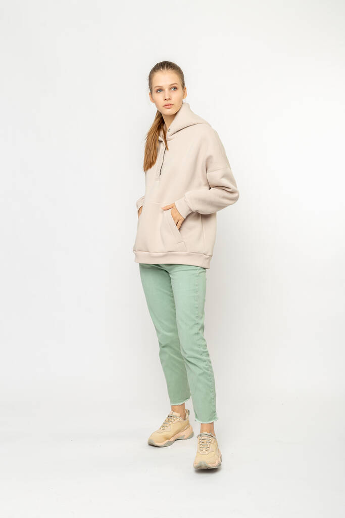 Chica en pantalones de carga verde y sudadera con capucha beige aislada en blanco - Foto, Imagen
