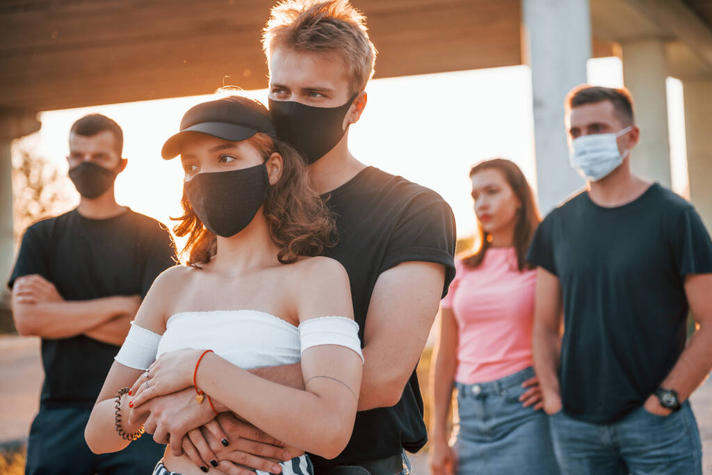 Paar umarmt einander. Gruppe protestierender junger Leute, die zusammenstehen. Aktivist für Menschenrechte oder gegen die Regierung. - Foto, Bild