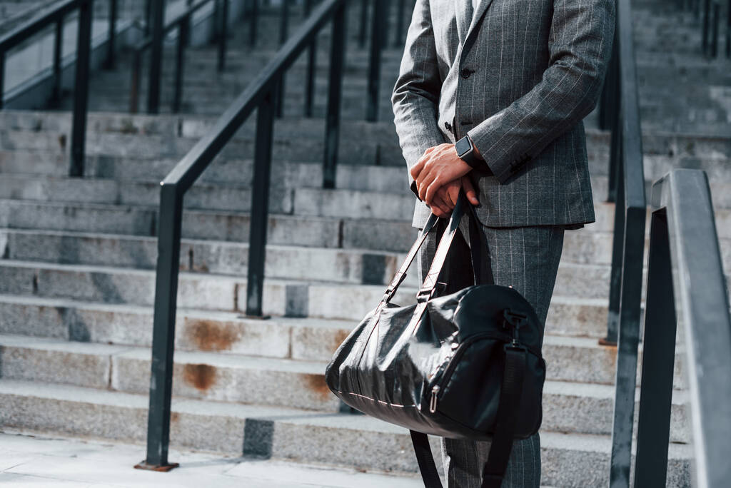Молодий успішний бізнесмен у сірому формальному одязі на вулиці в місті
. - Фото, зображення