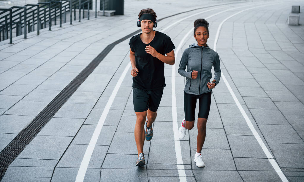 Europese man en Afro-Amerikaanse vrouw in sportieve kleding hebben samen workout. - Foto, afbeelding