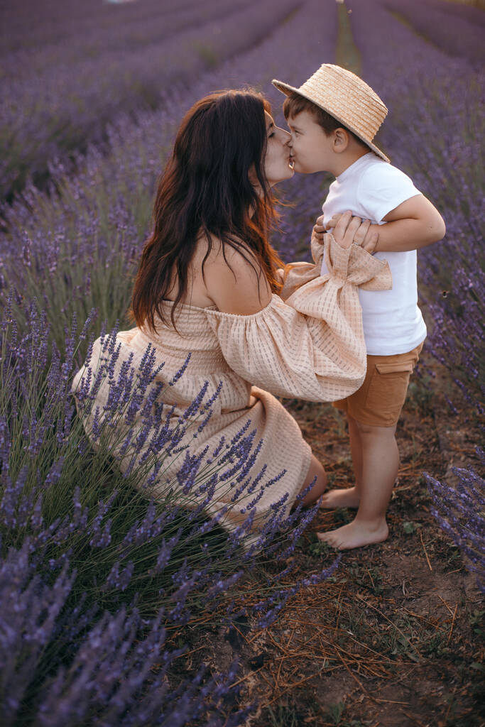 Viehättävä valkoihoinen äiti leikkii poikansa kanssa laventeli kentällä taustalla
 - Valokuva, kuva