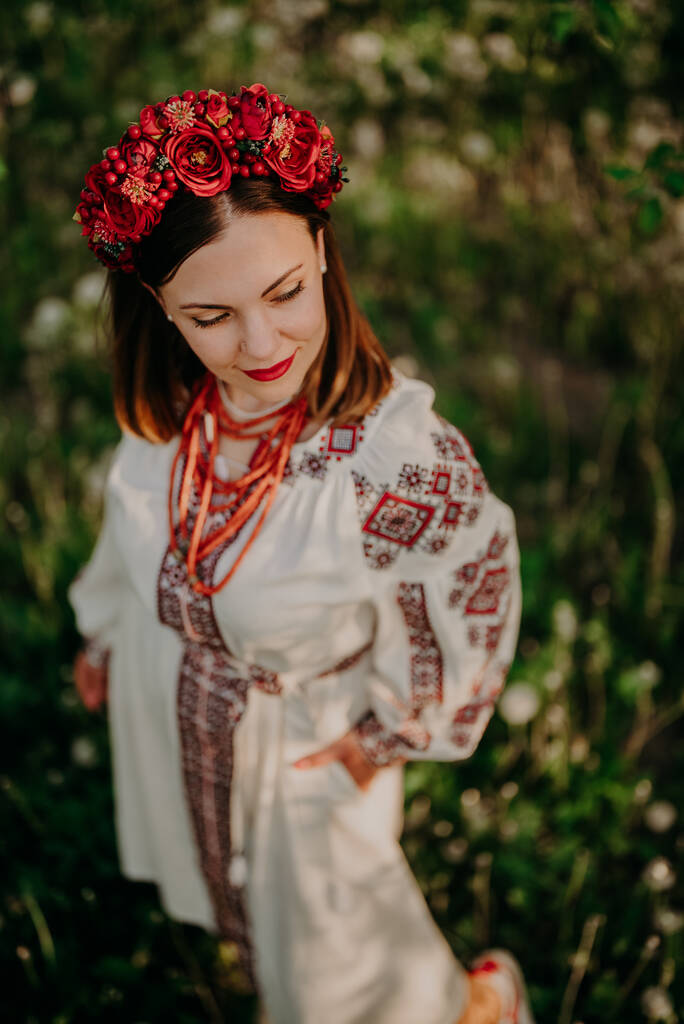 Atractiva mujer ucraniana en vestido tradicional bordado vyshyvanka, cuentas de coral antiguas y flores rojas corona. Ucrania, libertad, cultura, traje nacional, victoria en la guerra. - Foto, Imagen