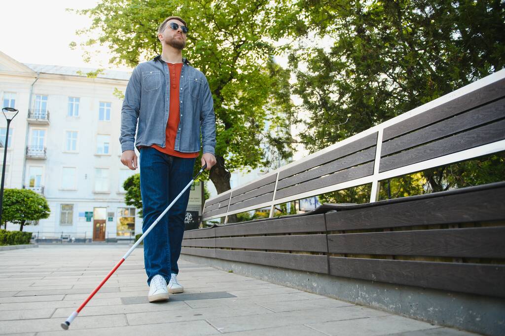 Giovane bell'uomo cieco che cammina con bastone in città. - Foto, immagini