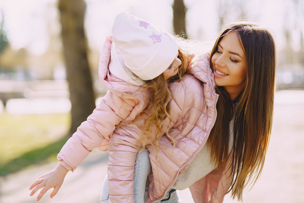 Mutter mit Tochter spielt im Frühlingspark - Foto, Bild