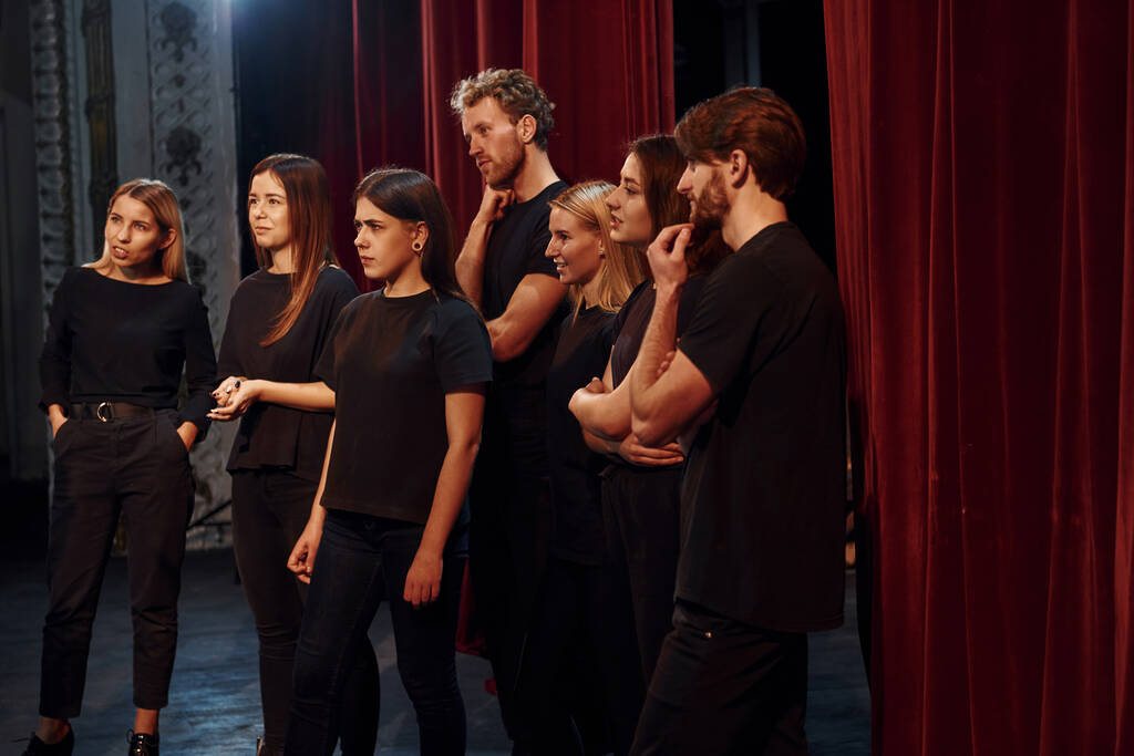 Vista lateral. Grupo de atores em roupas de cor escura no ensaio no teatro. - Foto, Imagem