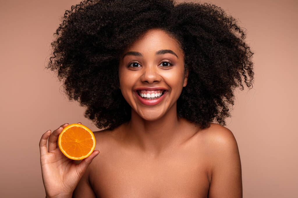 Alegre negro hembra mostrando naranja - Foto, Imagen