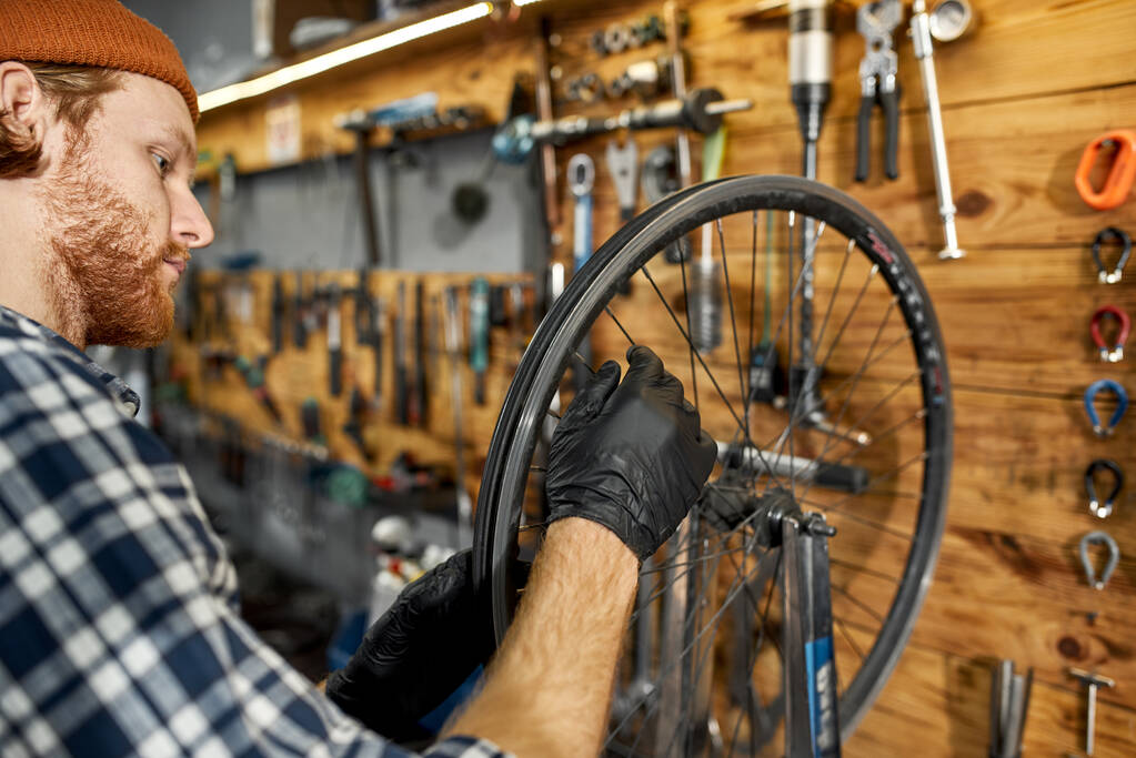 Szerelő ellenőrzése kerékpár kerék küllő műhelyben - Fotó, kép