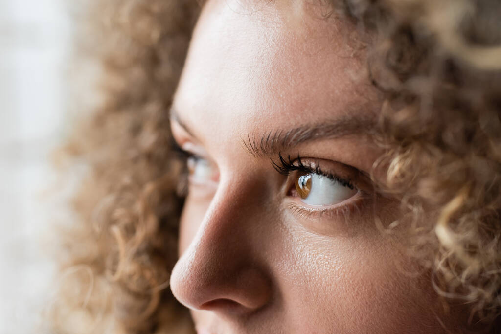 partial view of young woman with curly hair and brown eyes - Photo, Image