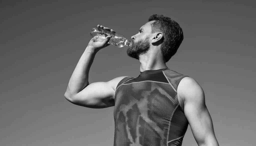 atleet die water drinkt vanwege dorst na training, sport en gezondheid. - Foto, afbeelding