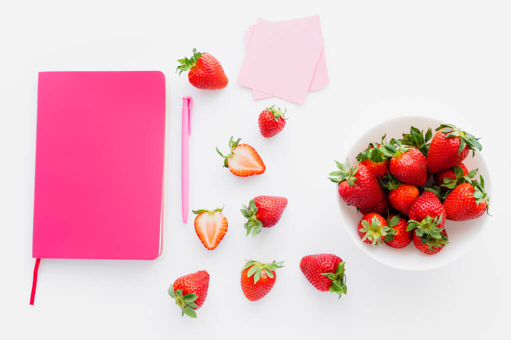 Vista dall'alto di notebook rosa e fragole fresche su sfondo bianco - Foto, immagini