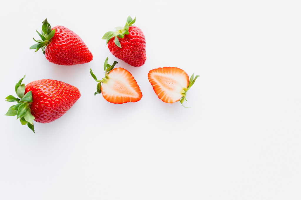 Vue de dessus des fraises biologiques avec des feuilles sur fond blanc  - Photo, image