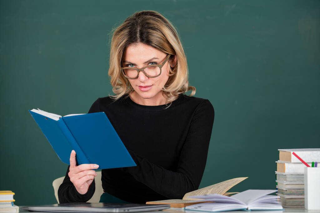 Día del maestro. Retrato de una maestra enseñando línea de estudiantes de secundaria con computadora portátil en el aula en pizarra - Foto, imagen
