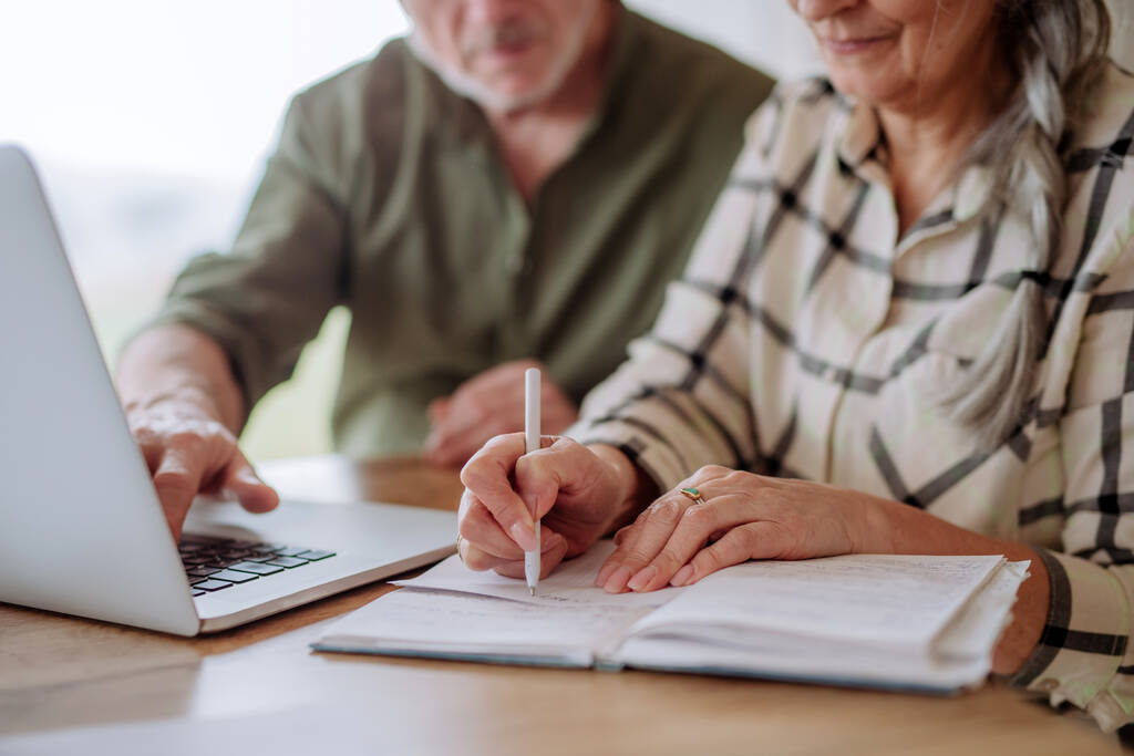 Nahaufnahme: Gestresstes Senioren-Paar berechnet Spesen oder plant Haushalt gemeinsam zu Hause. - Foto, Bild