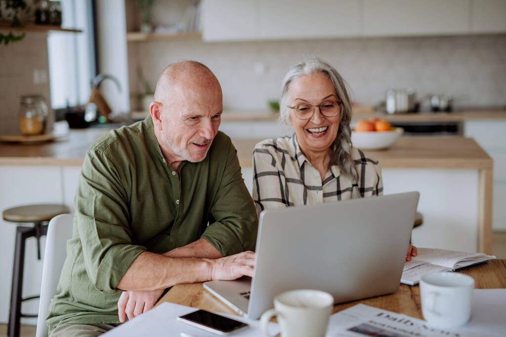 Una coppia anziana felice calcola le spese o pianifica il budget insieme a casa. - Foto, immagini
